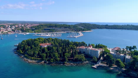 Rovinj,-Croatia-aerial-push-in-shot-flying-south-over-Katerina-island-towards-hotel-Marina