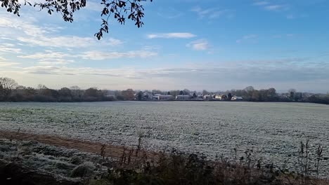 Frosty-white-winter-morning-farmland-meadow-under-cloudy-chilly-autumn-sunrise,-panorama-shot