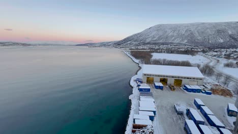 Wide-view-in-Tromso-Norway-of-lake-and-snow-covered-mountains,-with-shipping-containers-in-the-foreground