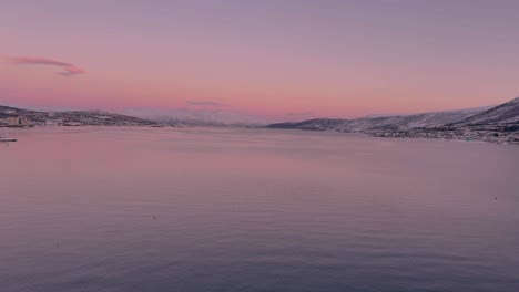 View-of-the-Norwegian-sea-from-Tromso-Norway,-calm-waters-and-snow-covered-mountains-in-the-distance