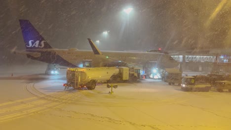 Verladen-Von-Gepäck-Und-Treibstoff-Ins-Flugzeug-Mit-Einem-Tankwagen-Am-Flughafen-Tromsø-Bei-Starkem-Nächtlichen-Schneefall
