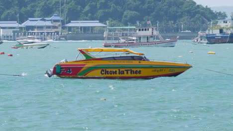 Ferries-and-speedboats-are-anchored-at-the-beachfront-of-Pattaya-Beach-as-some-are-sailing-by,-in-the-province-of-Chonburi-in-Thailand