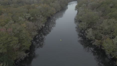Kayak-Verde-Remando-Lentamente-En-El-Centro-De-Un-Río-Tranquilo-En-Un-Día-Nublado-En-Edisto
