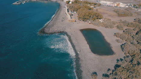 Orbital-aerial-view-of-the-puddle-and-rock-beach-of-the-city-of-Aldea-de-San-Nicolas-on-a-sunny-day