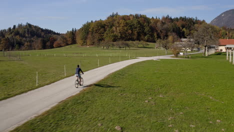 Young-man-cycling-individually,-enjoying-the-scenery-in-the-autumn,-aerial-shot