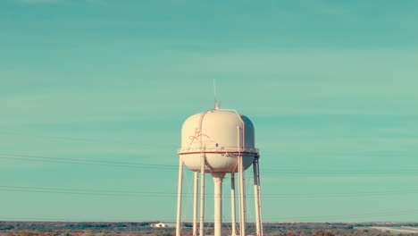 Aerial-drone-rise-up-of-Georgetown,-Texas-suburban-water-tower-in-neighborhood-of-sunny-fall-day