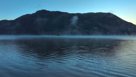 Volando-Bajo-Sobre-La-Superficie-Del-Lago-Mostrando-Niebla-Sobre-La-Superficie-Del-Agua-Antes-Del-Amanecer