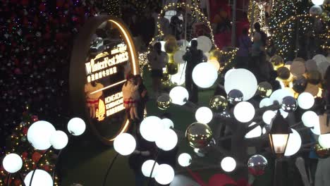 Visitors-look-at-the-twinkling-Christmas-Tree-in-West-Kowloon-cultural-district,-Hong-Kong,-China