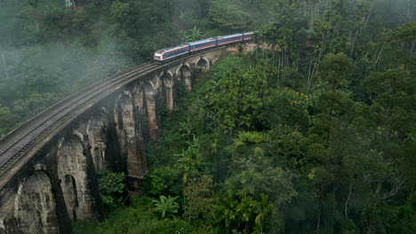 Aerial-Drone-Shot-of-Train-Passing-Over-Nine-Arches-Bridge-on-Foggy-Morning