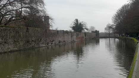 A-scenic-view-of-The-Bishop's-Palace-moat-during-winter-season-in-rural-countryside-of-Wells,-Somerset,-England