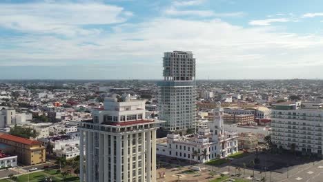 Aerial-In-downtown-Veracruz,-Mexico,-contemporary-architecture-rises-alongside-classic-structures-under-a-vast-sky