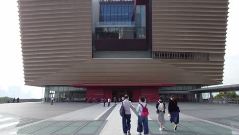 Los-Visitantes-Caminan-Hacia-El-Museo-Del-Palacio-En-El-Distrito-Cultural-De-West-Kowloon,-Hong-Kong,-China