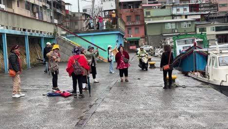 Tourists-happily-take-photos-at-the-famous-Zhengbin-Fishing-Port,-Zhongzheng-District,-Keelung,-Taiwan