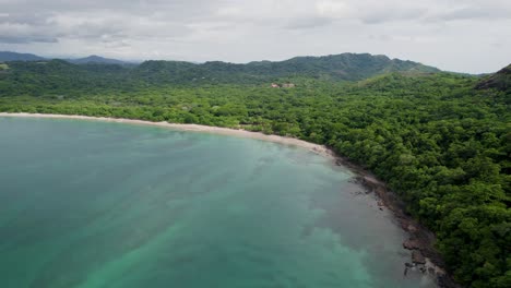 A-4K-drone-shot-of-Playa-Conchal,-or-“Shell-Beach”,-and-Puerto-Viejo,-next-to-the-Mirador-Conchal-Peninsula,-along-the-north-western-coast-of-Costa-Rica