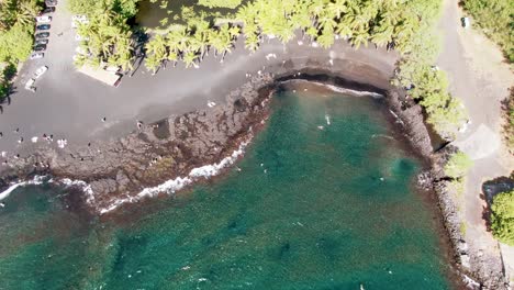 Aerial-of-coast,-green-landscape-and-road-by-Punalu’u-Beach,-Hawaii