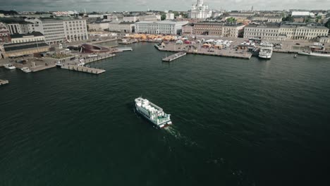 Aerial,-tour-boat-in-front-of-Helsinki-market-with-view-of-the-cathedral
