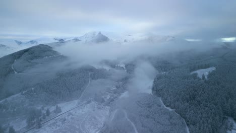 Auftauchen-Aus-Niedrigen-Wolken-über-Verschneiten-Winterwäldern-Und-Berglandschaften