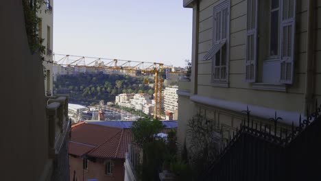 A-captivating-view-from-the-top-of-Monaco-reveals-a-descending-staircase-leading-to-the-port,-nestled-between-narrow-streets-and-stunning-buildings