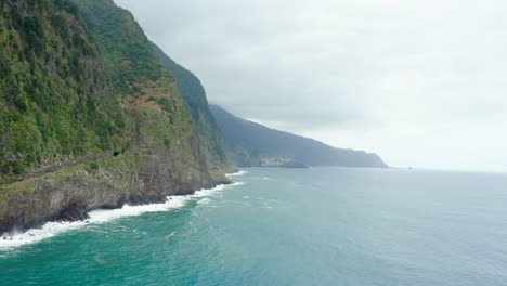 Küste-Mit-Wellen,-Berge-In-Wolken,-Panoramameerhorizont-Mit-Klippen,-Panoramahimmel,-Hebende-Drohnenaufnahme-Madeira