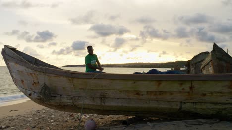 Schwarzer-Fischer-In-Afrika-Bereitet-Ein-Netz-In-Einem-Holzboot-Am-Tropischen-Strand-Für-Die-Fischerei-Im-Ozean-Vor.-Meeresfrüchte-Krise-Armutskonzept