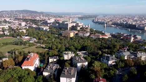 Vista-Panorámica-De-Retroceso-De-Drones-Sobre-El-Río-Danubio-Y-La-Colina-Del-Castillo-En-Budapest