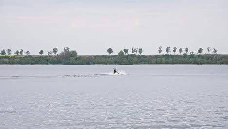 A-Speedboat-Maneuvering-Through-the-Lake,-Creating-a-Splash-of-White-Water-in-its-Wake---Wide-slow-motion-Shot
