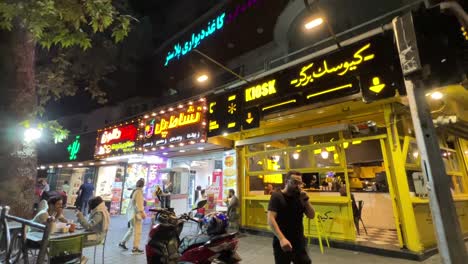 Tehran-Night-life-hamburger-burger-shop-in-Iran-Luxury-expensive-upscale-minimal-design-food-in-rich-street-life-fast-food-concept-pavement-hungry-people-pedestrian-yellow-color-light-design-turkish