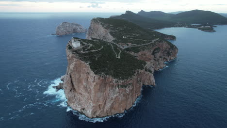 Orbital-aerial-view-of-the-cliff-and-lighthouse-located-on-Cape-Caccia-on-the-island-of-Sardinia-and-during-sunset