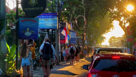 Tourist-couples-walking-on-man-road-in-Bali-during-vacation-time-at-sunset