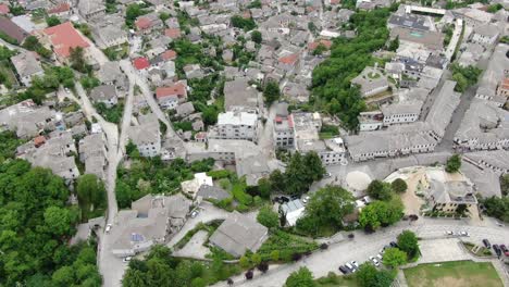 Drone-view-in-Albania-flying-in-Gjirokaster-over-a-medieval-town-showing-the-brick-brown-roof-houses