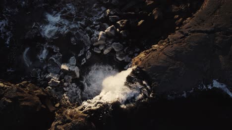 Masses-of-water-rush-down-river,-dramatic-light-waterfall,-aerial-top-down-orbit