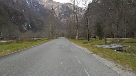 A-road-curls-in-the-valley-at-the-bottom-of-mountains-in-Cavergno,-Switzerland