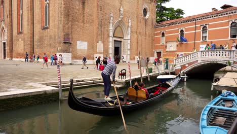Gondolier-starts-his-tourist-trip-while-keeping-an-eye-on-the-time