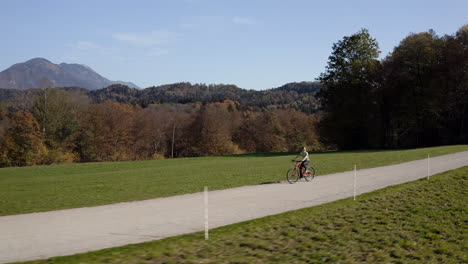 Girl-cycling-individually,-enjoying-the-scenery-in-the-autumn,-aerial-shot