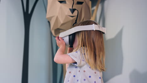 Niña-Pequeña-Con-Gafas-De-Realidad-Virtual-En-La-Sala-De-Juegos-De-Un-Museo,-Toma-De-ángulo-Bajo