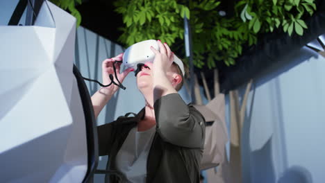 Woman-with-a-virtual-reality-headset-having-fun-in-a-museum-VR-room,-low-angle