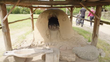 Ancient-clay-oven-for-baking-bread-in-Biskupin-settlement,-Poland---tilt-up-shot.