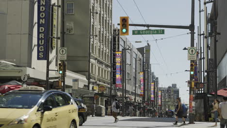 Fußgänger-überqueren-Die-Granville-Street-Ecke-West-Georgia-Street-In-Vancouver-An-Einem-Sonnigen-Tag,-Handheld,-Statisch,-Zeitlupe