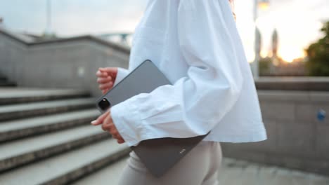 Modern-young-businesswoman-with-tablet-walk-up-stairs-against-urban-background,-concept-career-advancement-female-empowerment