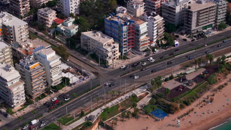 Circling-aerial-shot-of-a-tram-approaching-a-road-junction