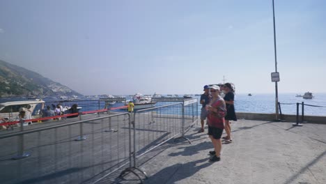 Amalfi-Positano-Italien-Immersiver-Reisetourismus-Mittelmeerküste-Wasser-Europa,-Wandern,-4k-|-Touristen-Beobachten,-Wie-Boote-Vom-Pier-Abfahren