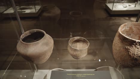 ancient-ancient-clay-pots-in-glass-case-at-the-exhibition-in-the-museum-of-Biskupin,-Poland