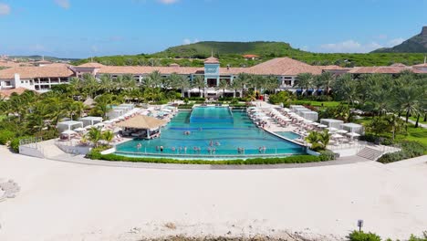 Drohne-Steigt-über-Weißen-Sand-Auf,-Um-Den-Atemberaubenden-Tropischen-Infinity-Pool-Im-Resort-In-Der-Karibik-Zu-Präsentieren