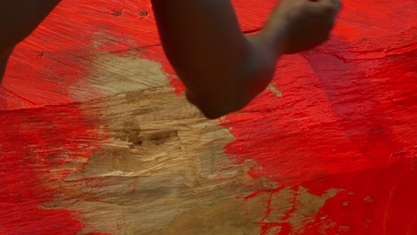 Un-Par-De-Amigos-Africanos-Hombres-Negros-Pescadores-Haciendo-Trabajos-De-Mantenimiento-En-Su-Barco-Tradicional-De-Madera-Pintándolo-En-Rojo