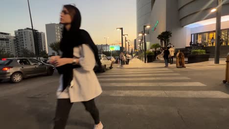 People-go-out-for-shopping-in-a-big-city-in-sunset-twilight-in-urban-life-city-landscape-heavy-traffic-big-building-tall-sky-scraper-residential-towers-luxury-mall-shopping-center-fresh-grocery-store