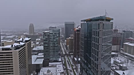Aerial-view-down-snowy-Salt-Lake-City-main-street-past-Wells-Fargo-Center
