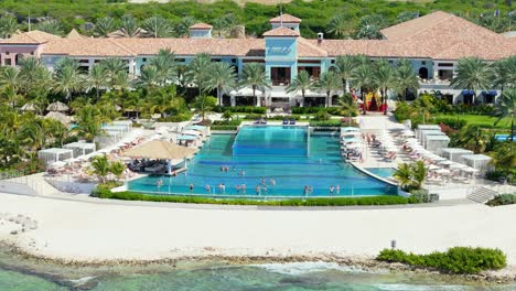 Medium-view-of-hotel-guests-relaxing-in-infinity-pool-looking-out-over-Caribbean-sea,-Curacao