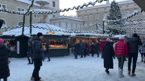 Christmas-winter-markets-in-European-city-Salzburg,-panning-shot,-snow-covered