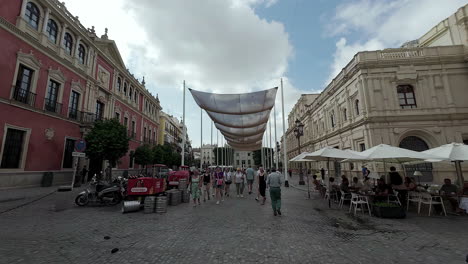 Gente-Caminando-Bajo-Un-Dosel-De-Sombrillas-En-La-Plaza-De-San-Francisco-En-Sevilla,-España