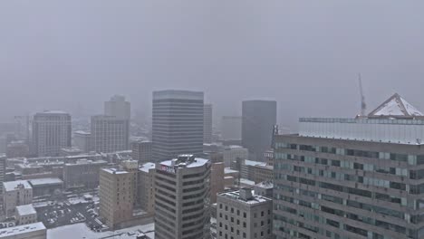 Grauer,-Verschneiter-Himmel-über-Der-Skyline-Von-Salt-Lake-City-Im-Winter,-Luftwagen